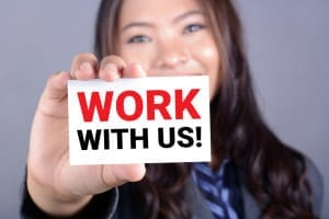 Girl holding sign 'Work with Us'